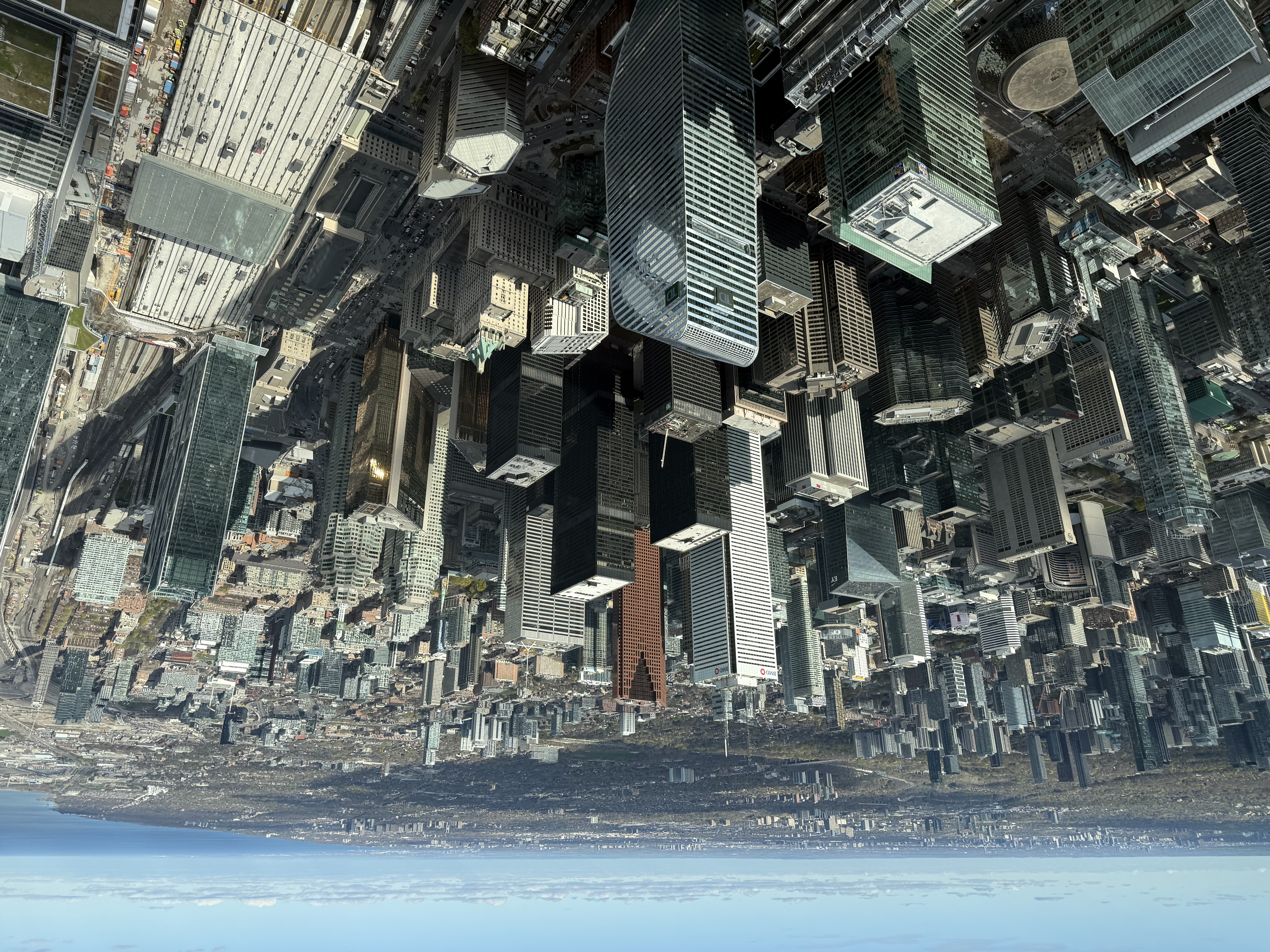 Aerial descent over Toronto — glass towers and Lake Ontario, communicating urban scale and modern destination management